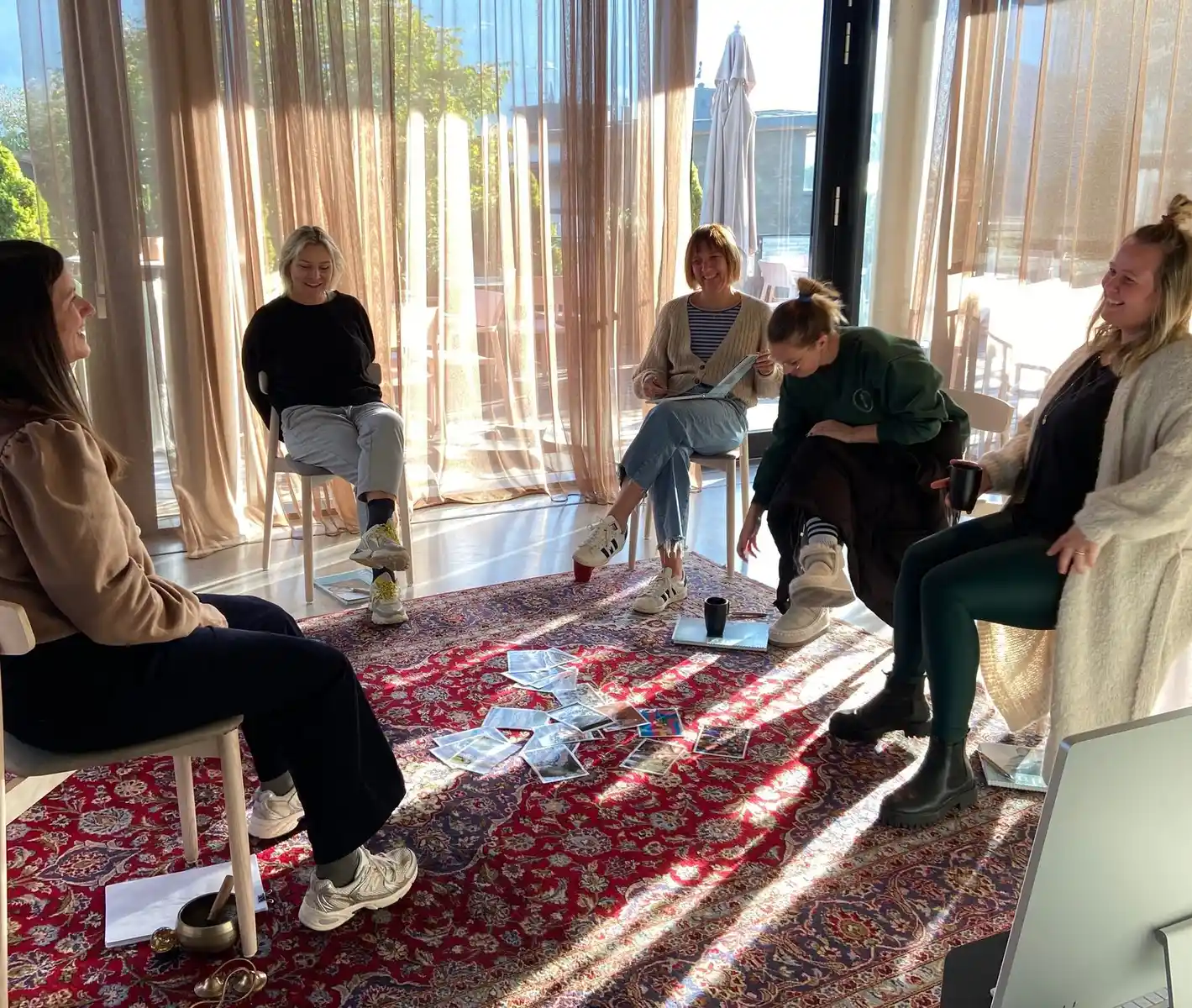 Teilnehmer eines Workshops stehen im Kreis, arbeiten mit Karten auf dem Boden und nehmen aktiv am Resilienztraining teil